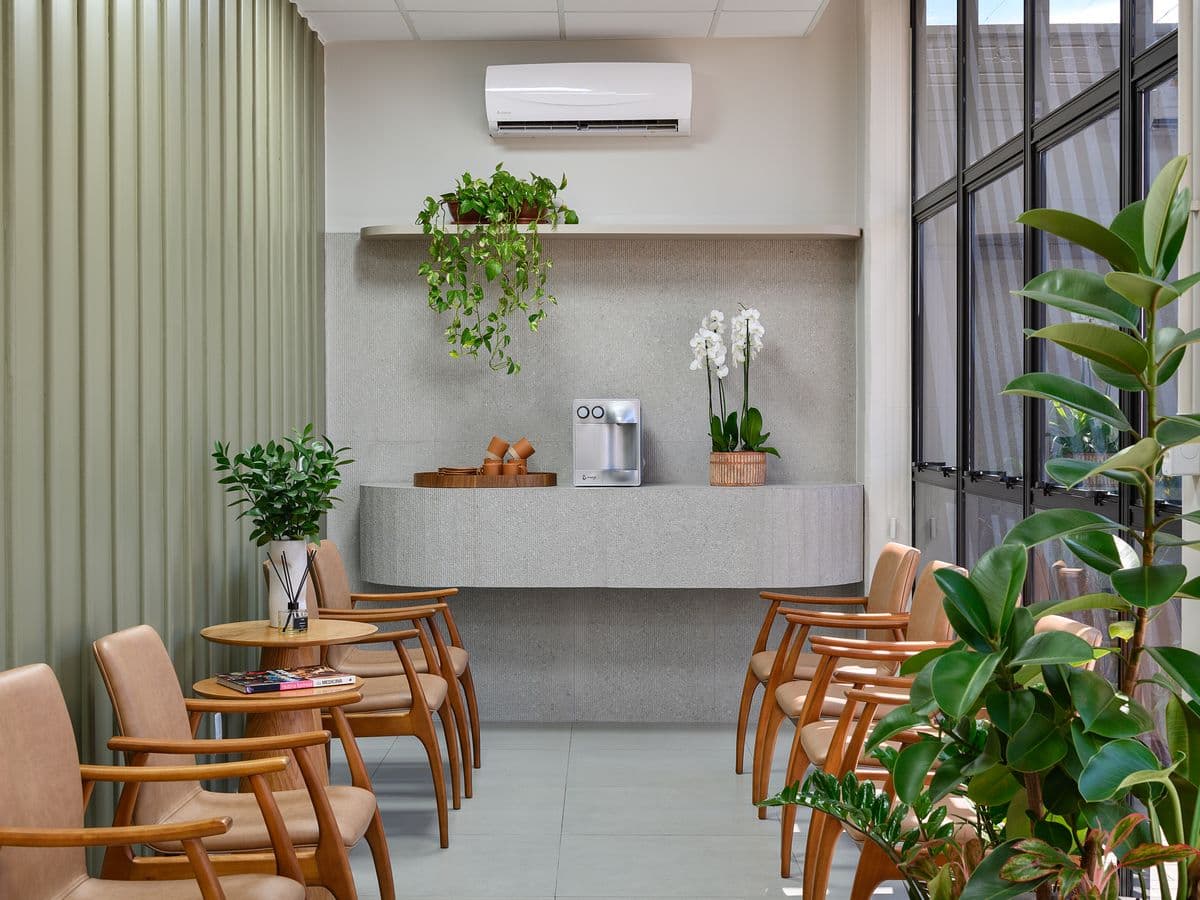 Espaço de espera com poltronas e plantas